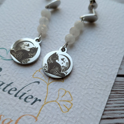 Gros plan sur le médaillon gravé motif chat des boucles d'oreilles artisanales Vanessa Créa.