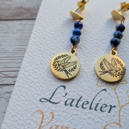 Gros plan sur le médaillon gravé motif hirondelle et les perles bleues des boucles d'oreilles artisanales Vanessa Créa.
