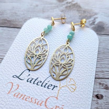 Gros plan sur la découpe du lotus en laiton et les perles facettées d'amazonite des boucles d'oreilles faites main.