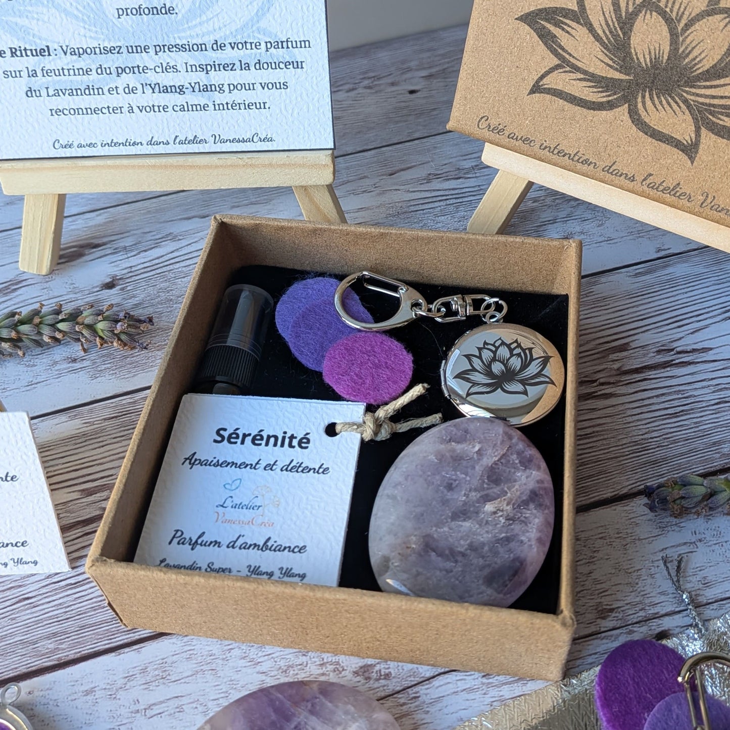 Gros plan sur l'intérieur du coffret Sérénité ouvert, montrant la feutrine violette, le flacon de parfum et la carte explicative en arrière-plan.