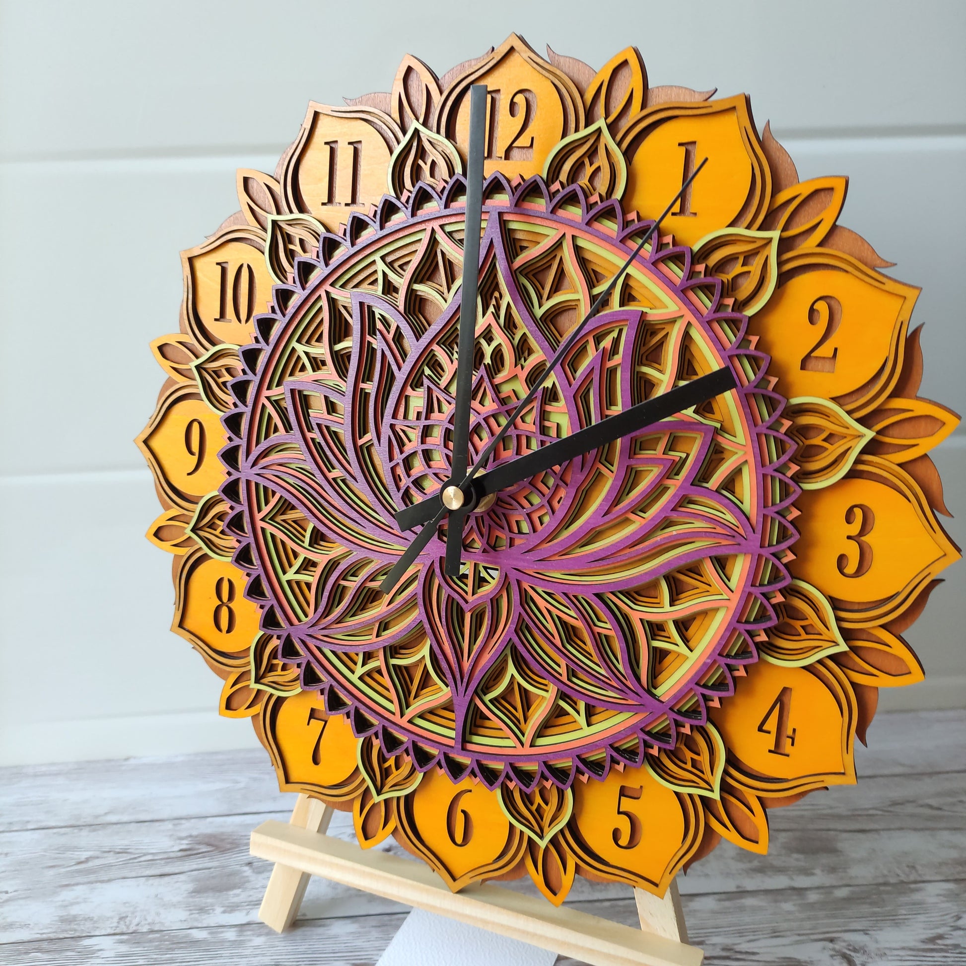 Vue de trois-quarts de l'horloge mandala fleur de lotus en bois, mettant en valeur son relief et ses couleurs.