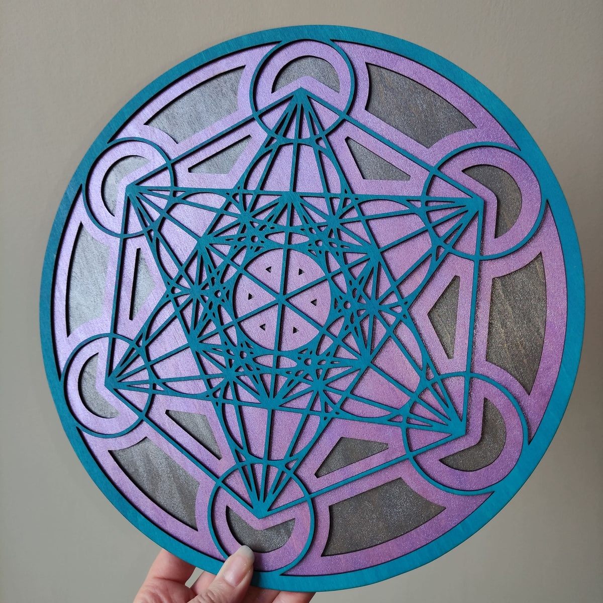 Cube de Métatron violet en bois tenu à la main pour montrer la taille