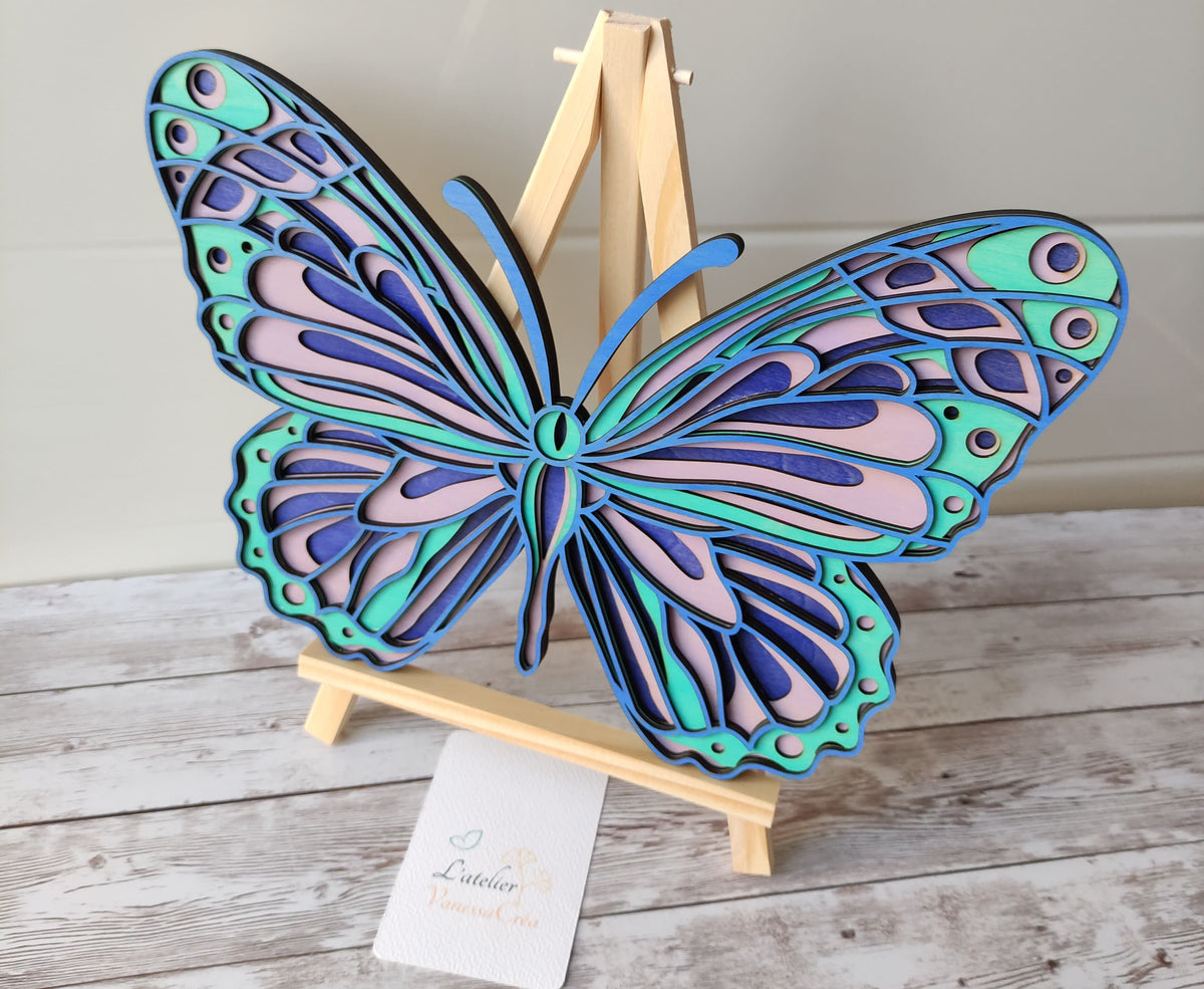 Papillon décoratif en bois 4 couches présenté sur un chevalet, parfait pour une décoration d'intérieur colorée.