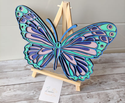 Papillon décoratif en bois 4 couches présenté sur un chevalet, parfait pour une décoration d'intérieur colorée.