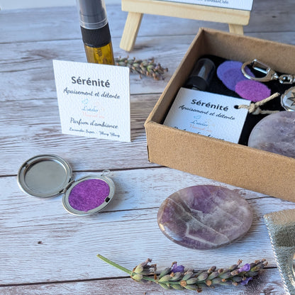 Focus sur le flacon de parfum d'ambiance bio, le médaillon porte-clés ouvert avec feutrine violette et le galet d'améthyste du coffret Sérénité.