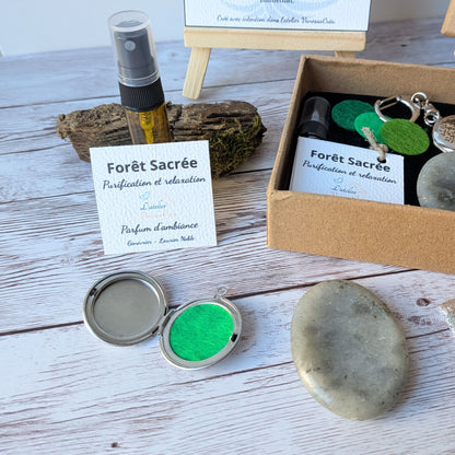 Focus sur le flacon de parfum d'ambiance bio Forêt Sacrée, le médaillon porte-clés ouvert et le galet de labradorite du coffret Forêt Mystique.