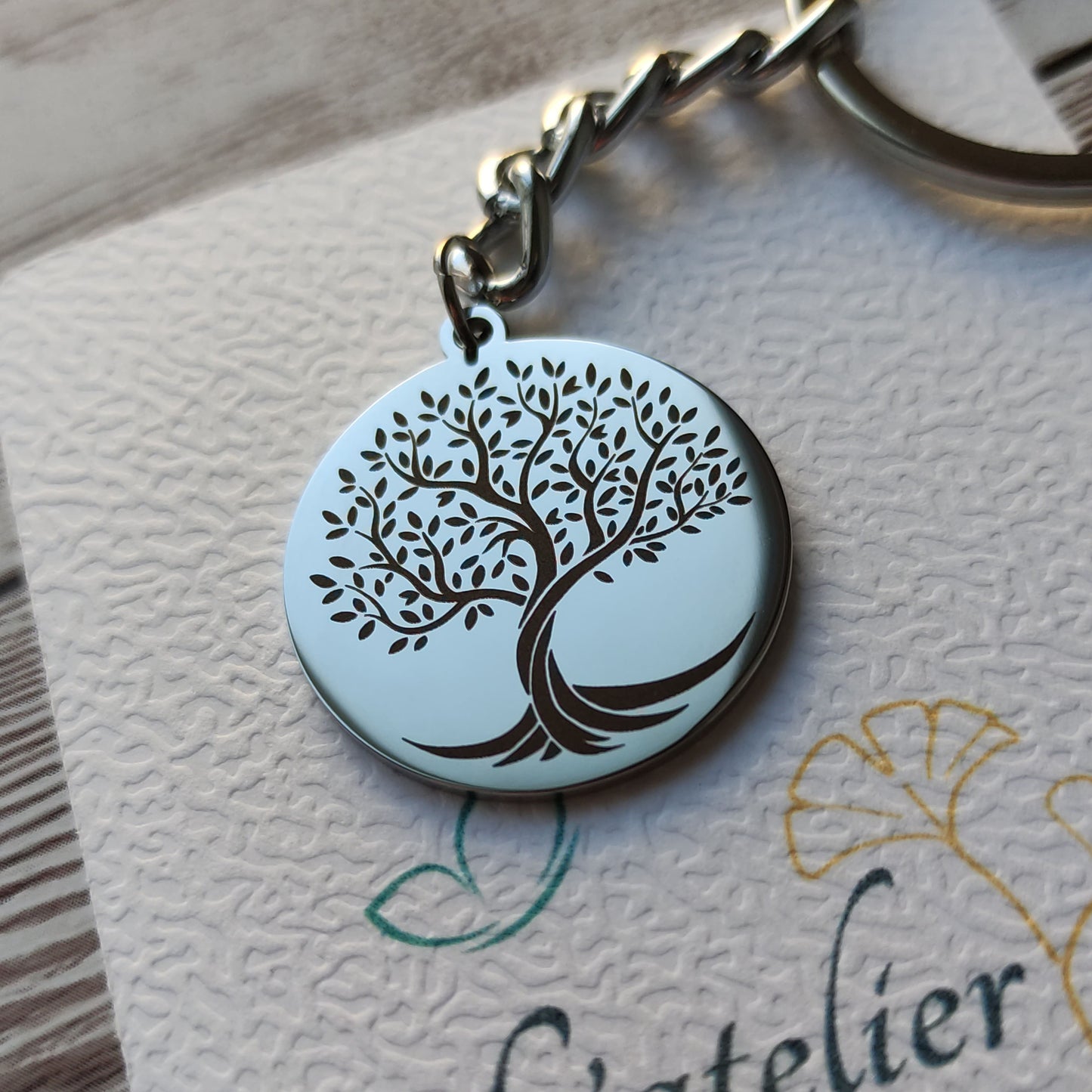 Porte-clé rond en acier inoxydable poli miroir avec gravure de précision d'un Arbre de Vie et texte personnalisé au verso.