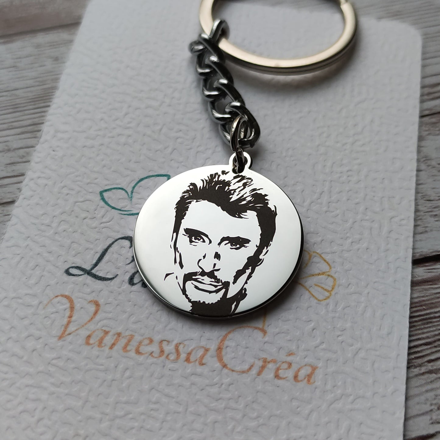 Porte-clés rond en acier inoxydable poli miroir avec gravure laser de précision de la tête de Johnny Hallyday.