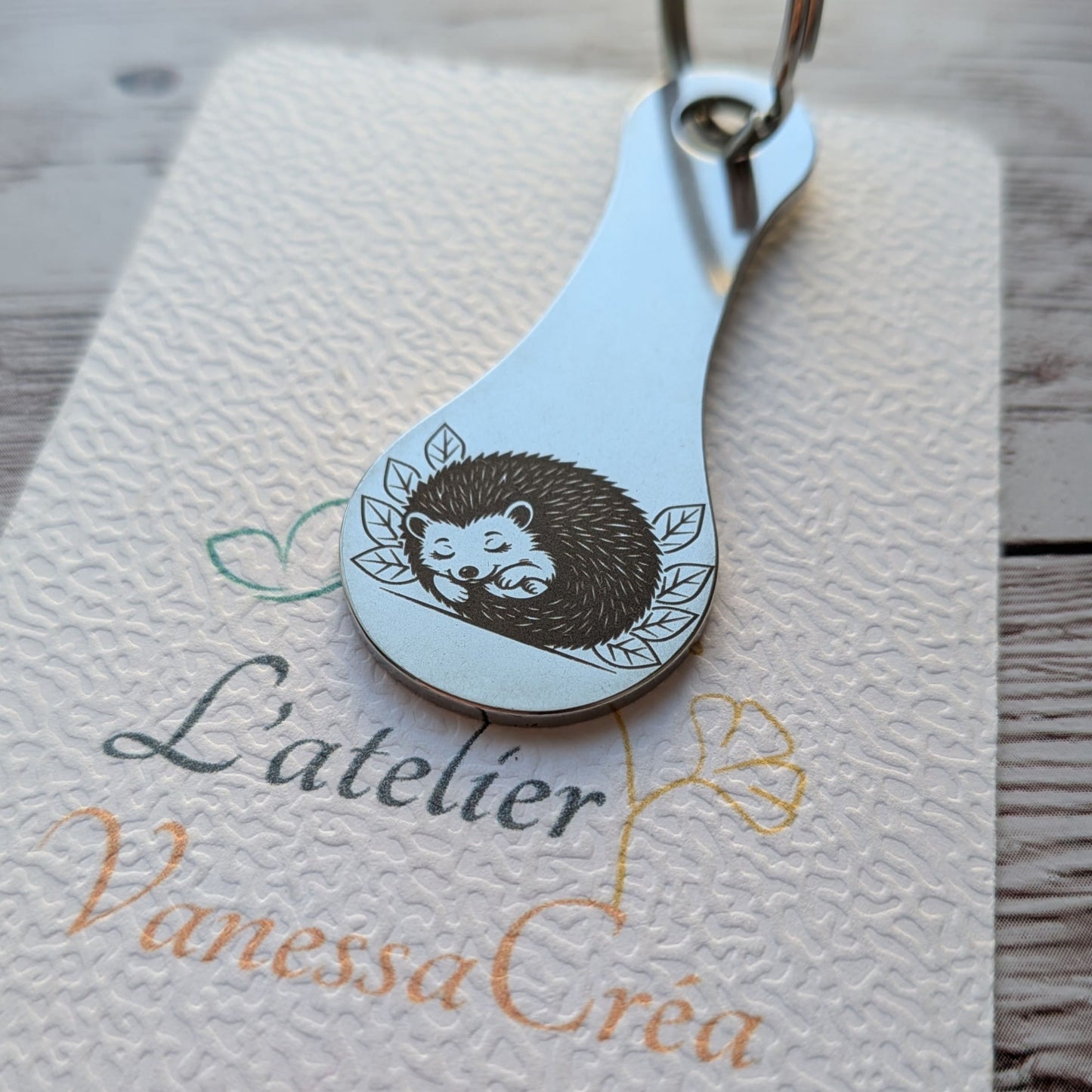 Porte-clés jeton de caddie en acier inoxydable gravé d'un adorable hérisson endormi au milieu des feuilles, création L'Atelier VanessaCréa.