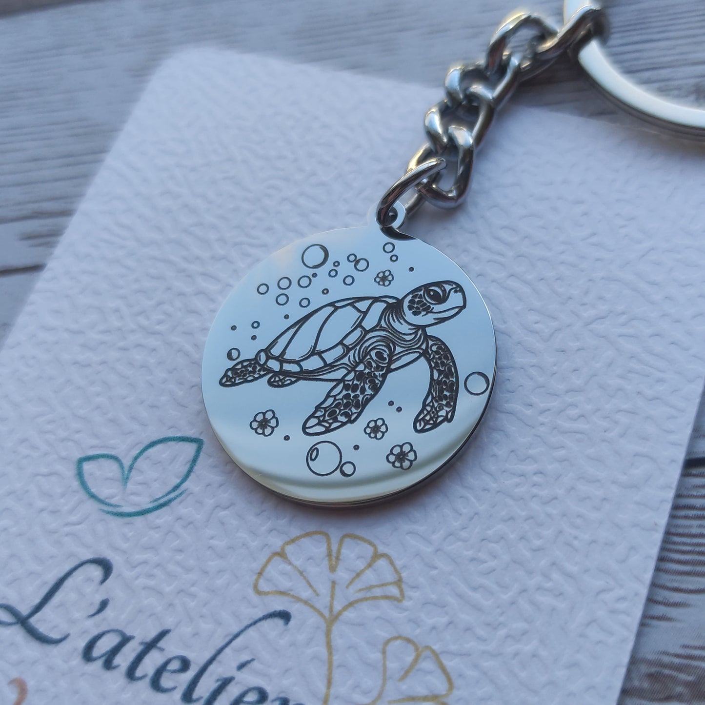 Porte-clés rond acier poli miroir avec gravure précision tortue marine.