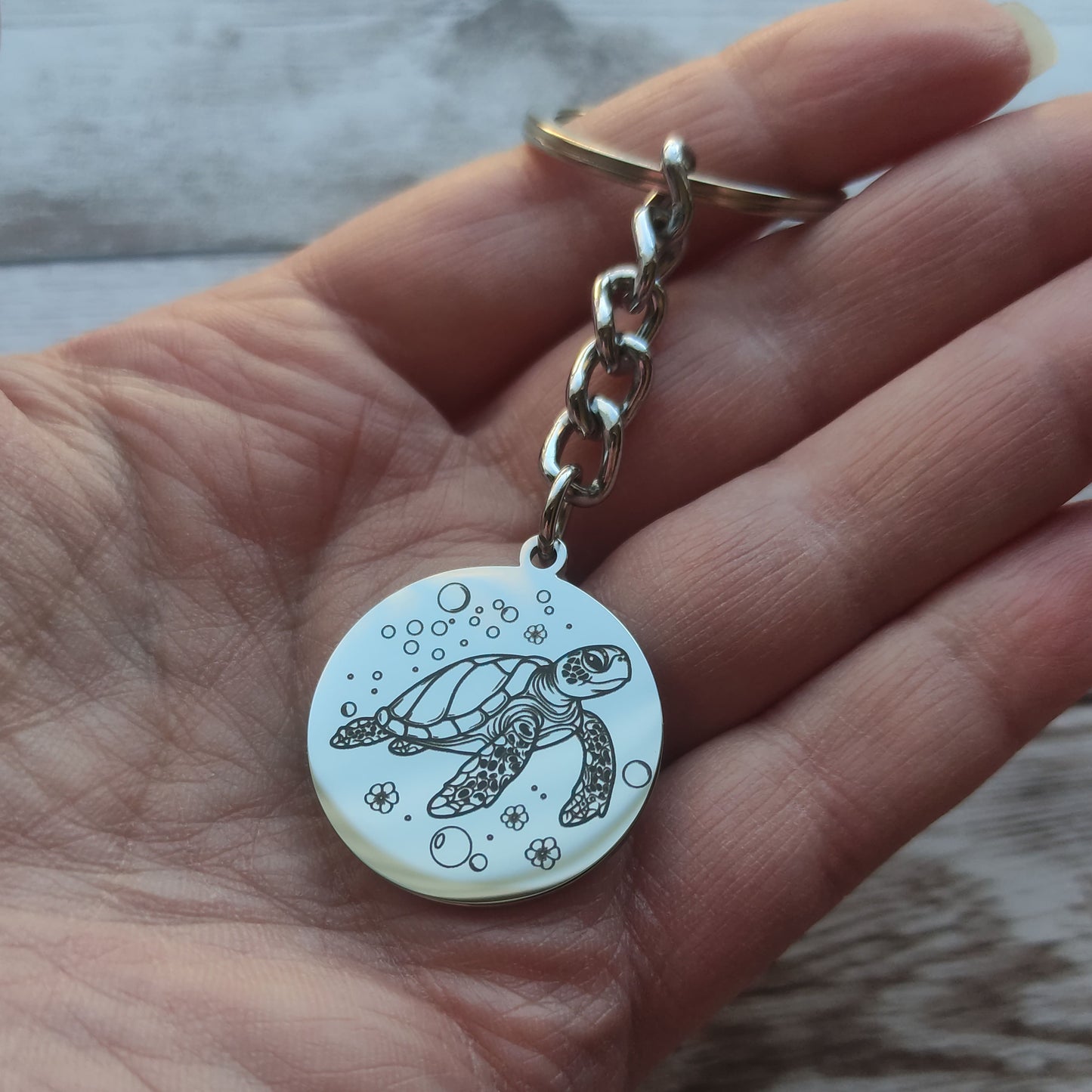 Porte-clés rond acier poli miroir avec gravure précision tortue marine.