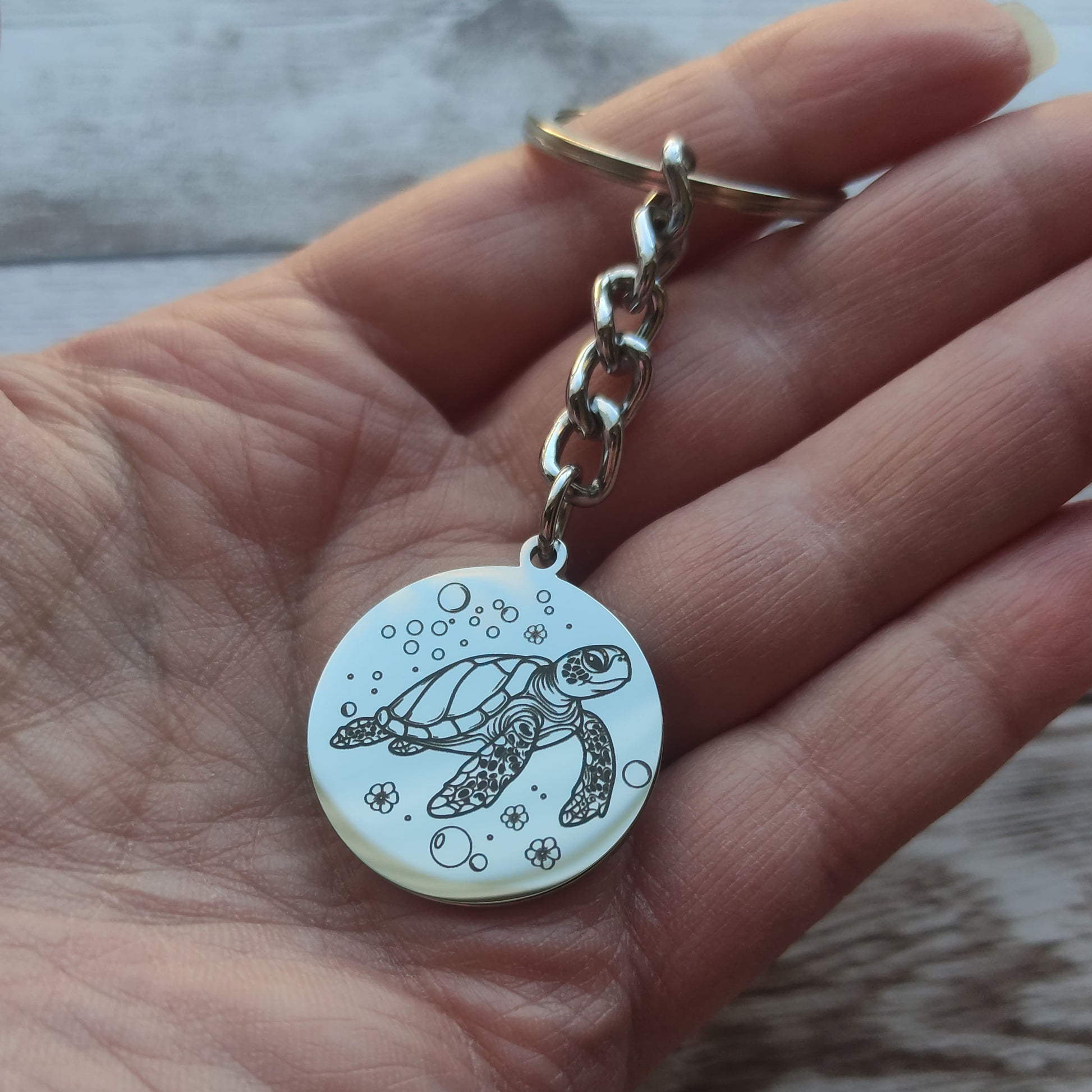 Porte-clés rond acier poli miroir avec gravure précision tortue marine.