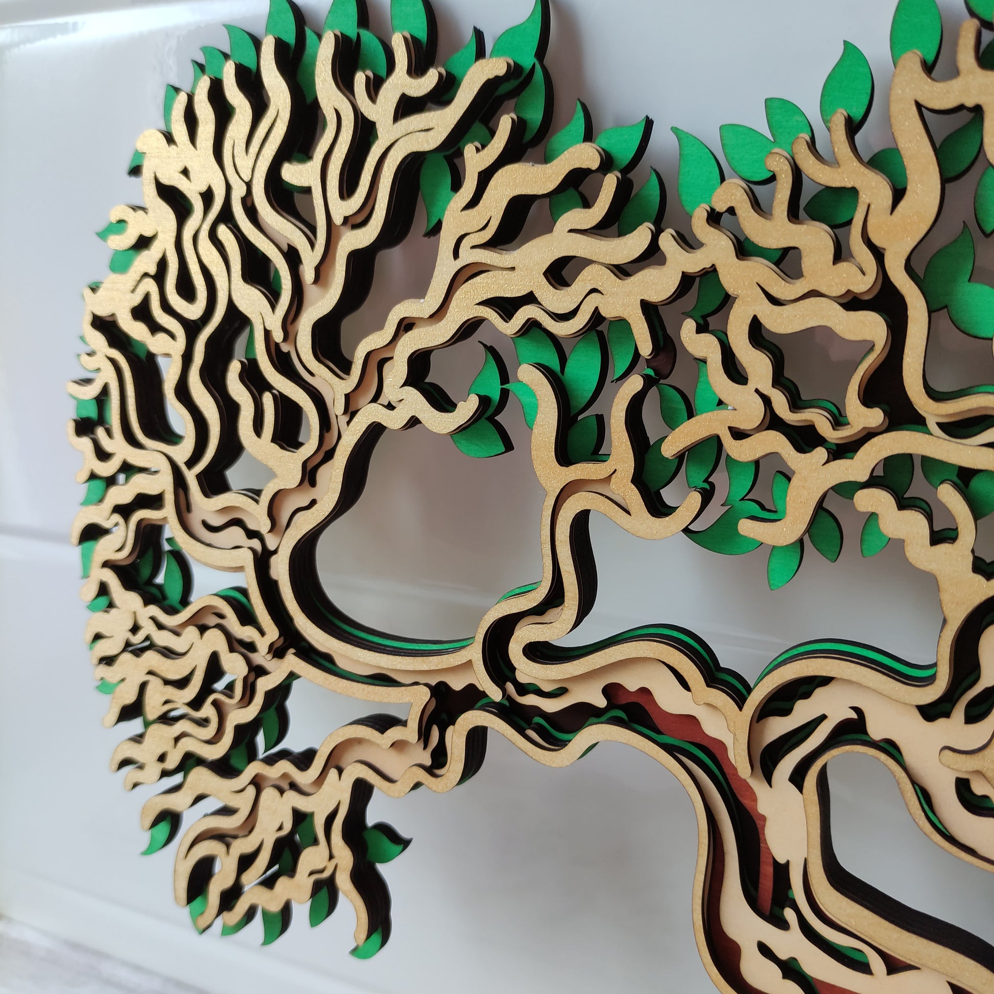 Vue de trois-quarts de l'Arbre de Vie en forme de cœur, mettant en évidence la superposition des 5 couches de bois.