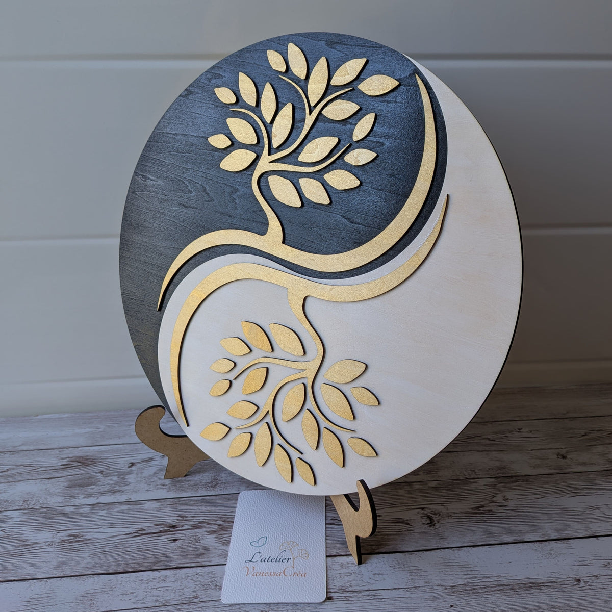 Décoration zen ronde Yin et Yang Arbre de Vie en bois, finition dorée, posée sur un support en bois.